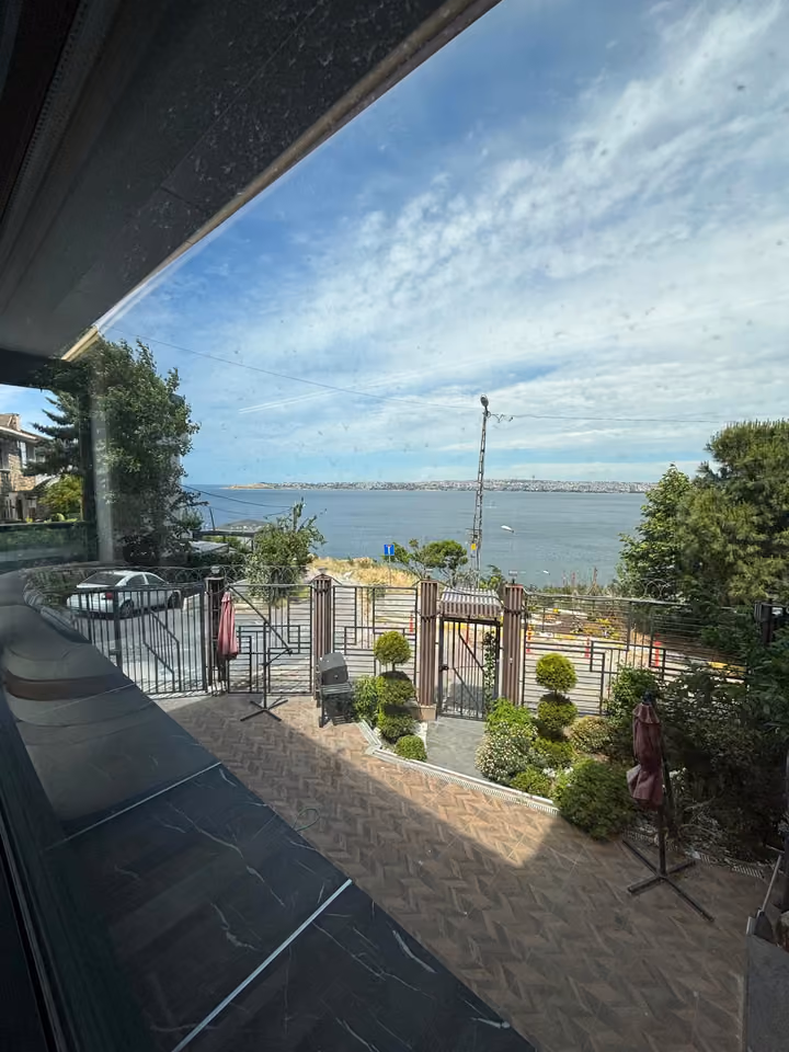 Courtyard and sea view photographed through a window.