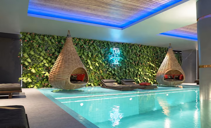 Architectural rendering of indoor pool with hanging lounge chairs.