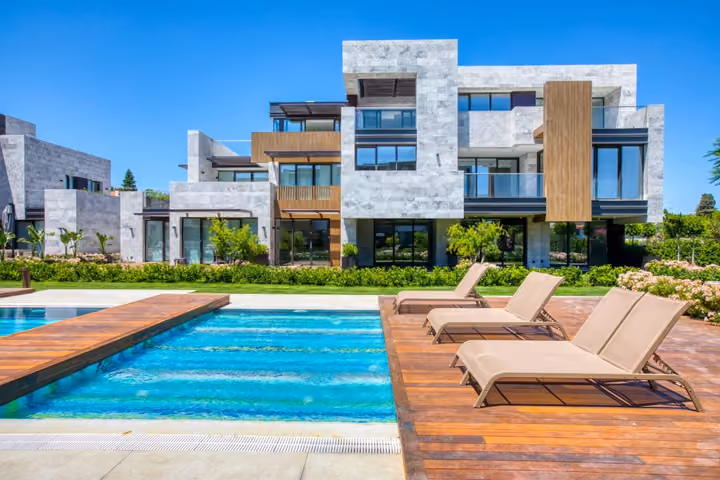 Pool deck facing stone clad apartments in Boyalik, Cesme.