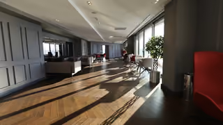 Shared lounge with seating and large windows.