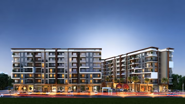 Architectural rendering showing the residential frontage, balconies and illuminated ground floor at dusk.