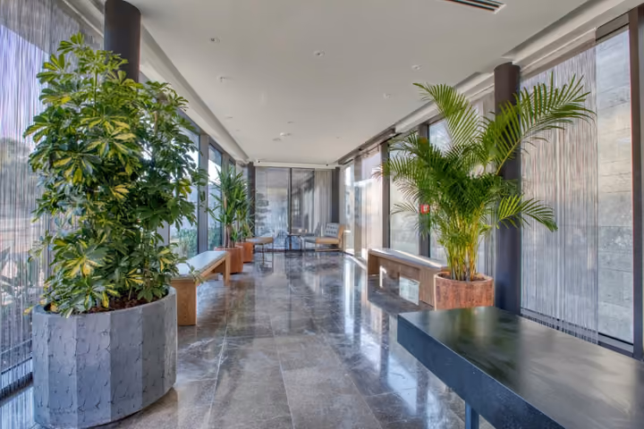 Glazed lobby corridor beside landscaped gardens in Boyalik, Cesme.