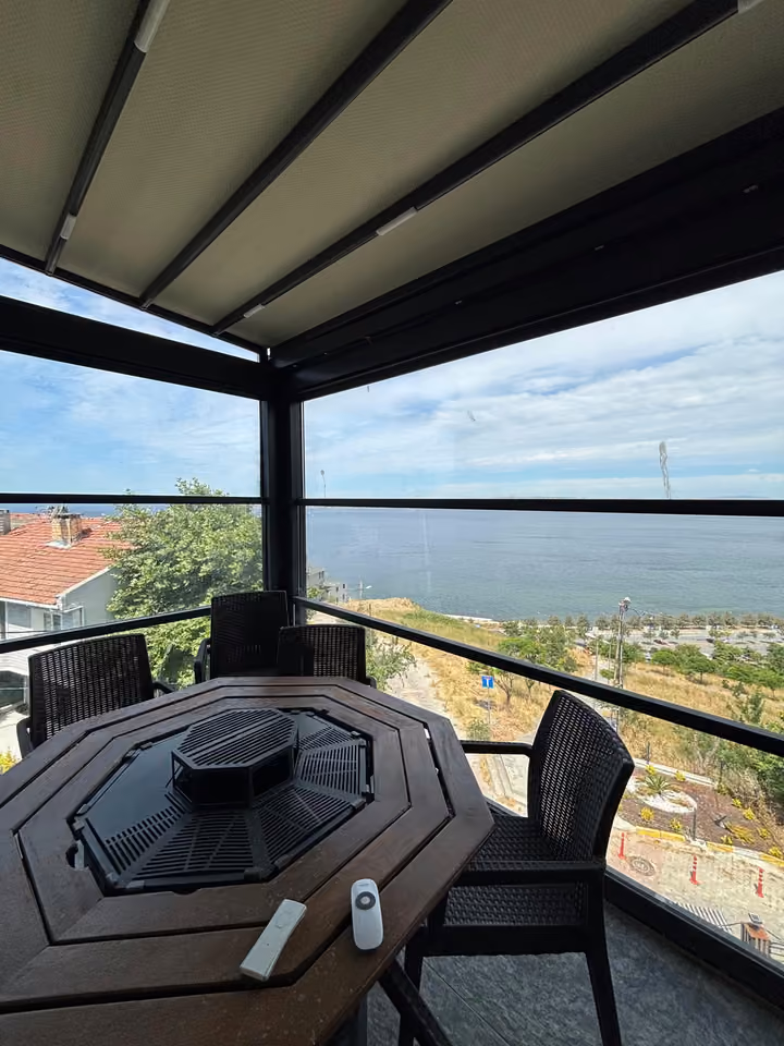 Dining table on the enclosed terrace overlooking the sea.