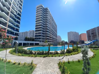 A landscaped path between the residential buildings and shared pool.