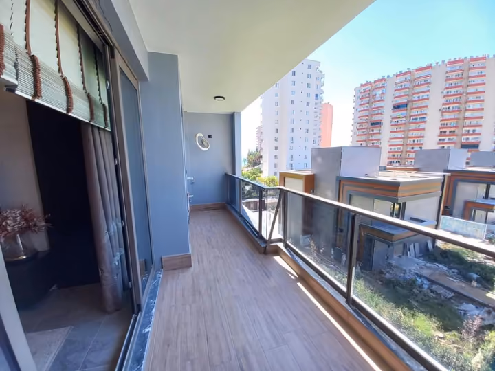 A photographed show apartment balcony facing nearby buildings and the street.