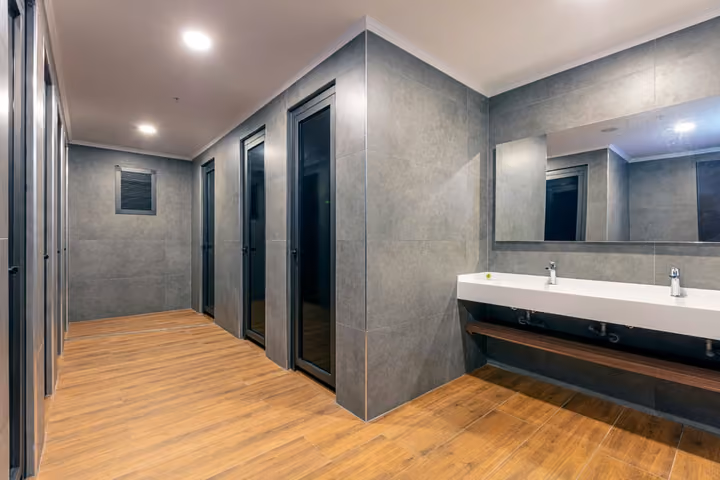Photograph of changing-room washbasins and shower entrances.