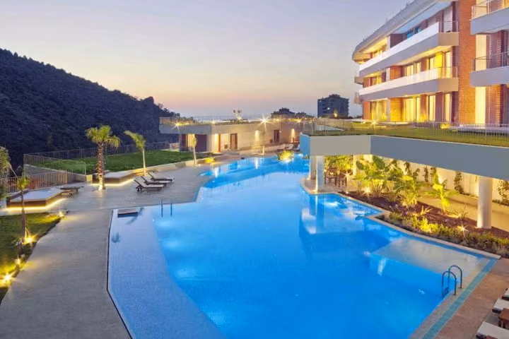 Communal pool and residences illuminated at dusk.