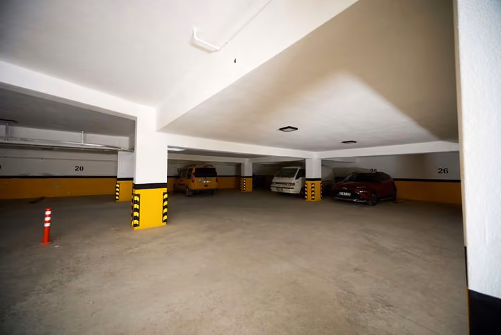 Underground parking area with marked bays and structural columns.