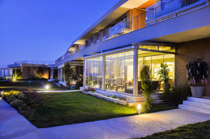 Illuminated garden apartment exterior at night.