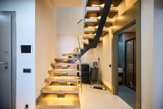 Illuminated internal staircase connecting the two levels of the duplex.