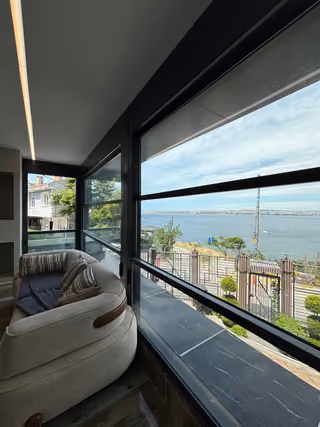 Living room seating beside windows overlooking the sea.