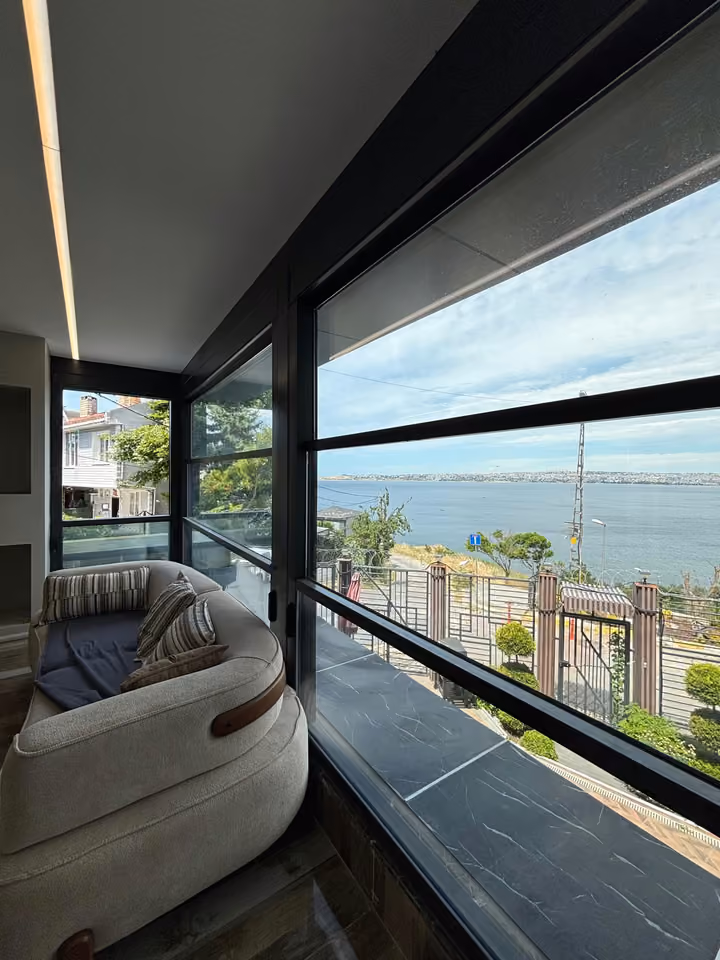 Living room seating beside windows overlooking the sea.