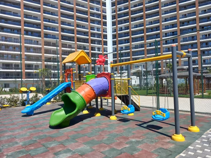 Children playground equipment and swings in the residential courtyard.