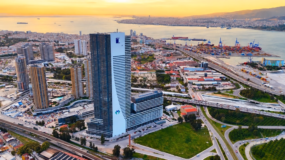 Aerial view of a high-rise building in Konak with Izmir Bay and the harbour in the background.