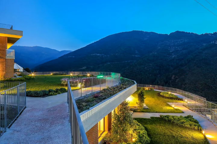 Terraced gardens and hillside illuminated at dusk.