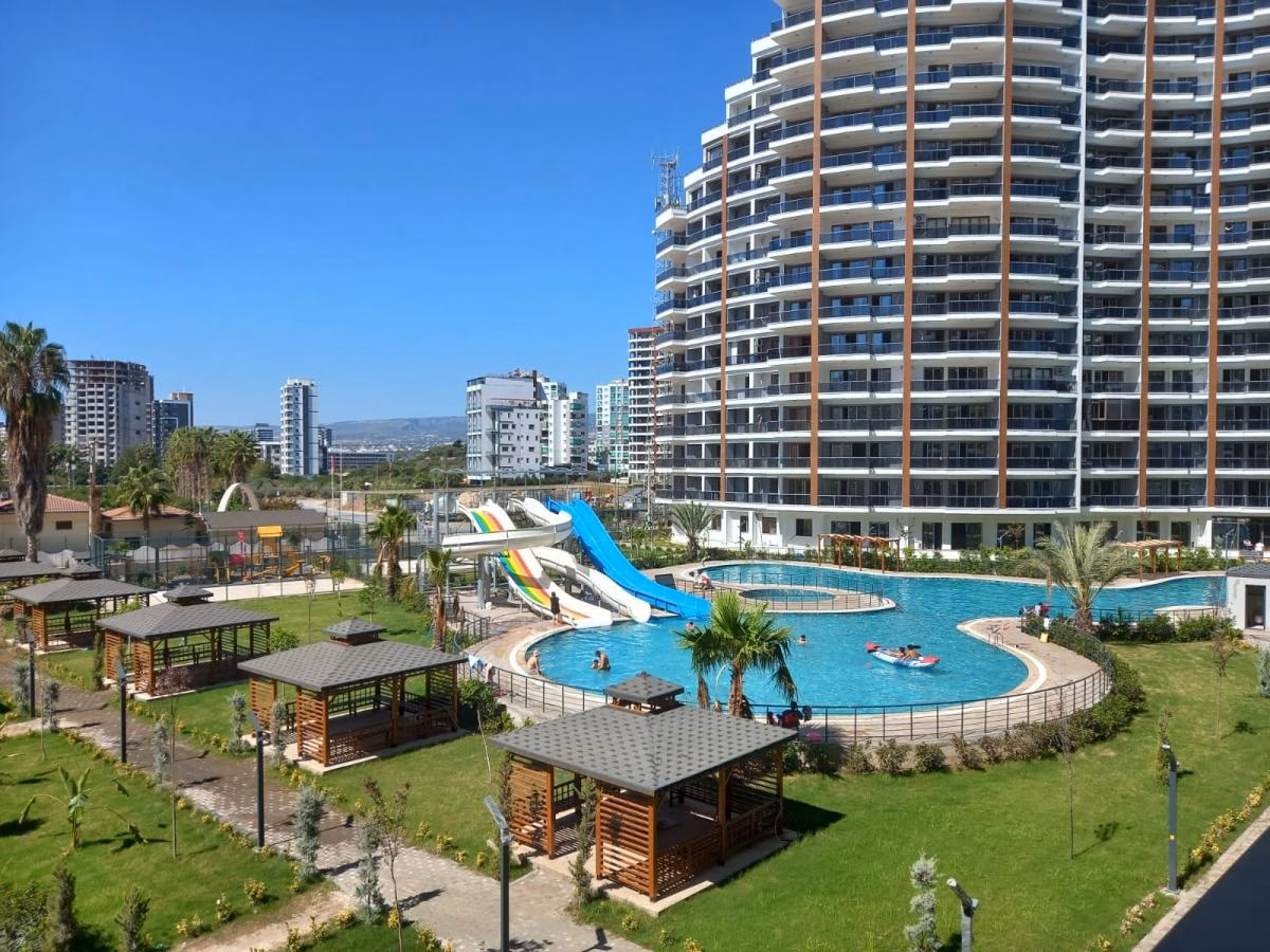 Residential buildings around the outdoor pool, water slides and landscaped courtyard.
