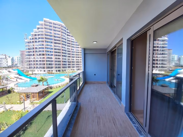 A show apartment balcony photographed toward the pool and inner courtyard.