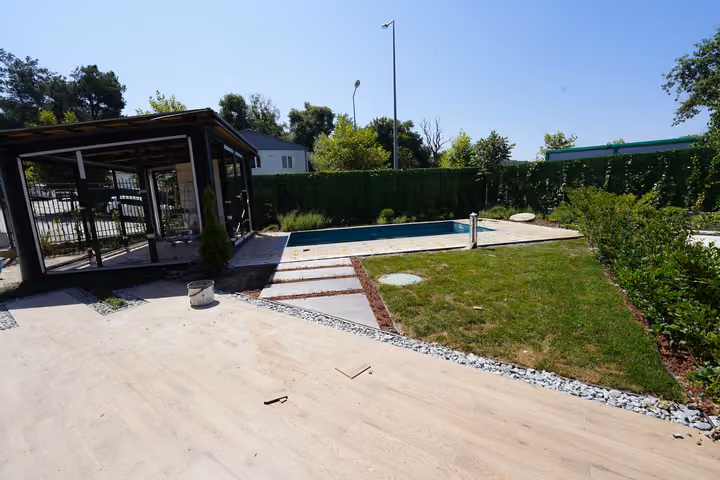 Photograph of a lawn, pool and glazed garden pavilion in Zekeriyakoy.