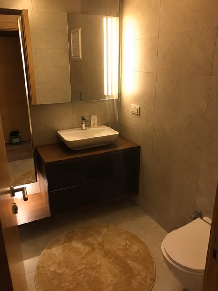 Bathroom with mirror and fitted vanity.