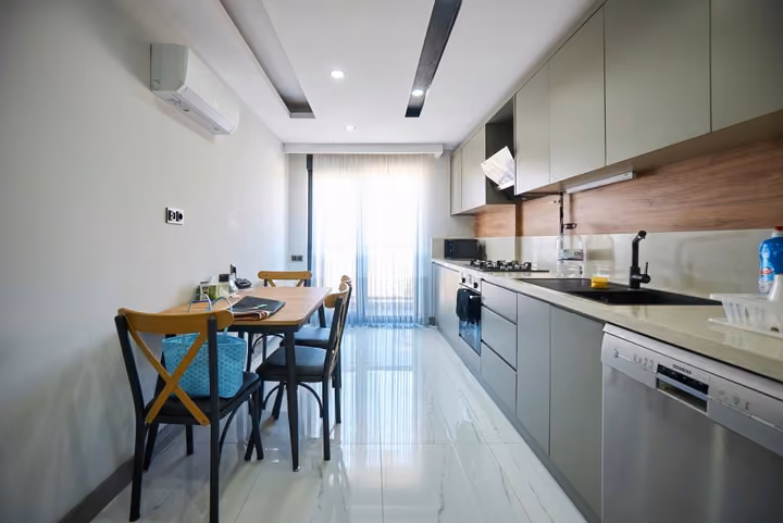 Separate fitted kitchen with appliances, a dining table and a glazed exterior door.