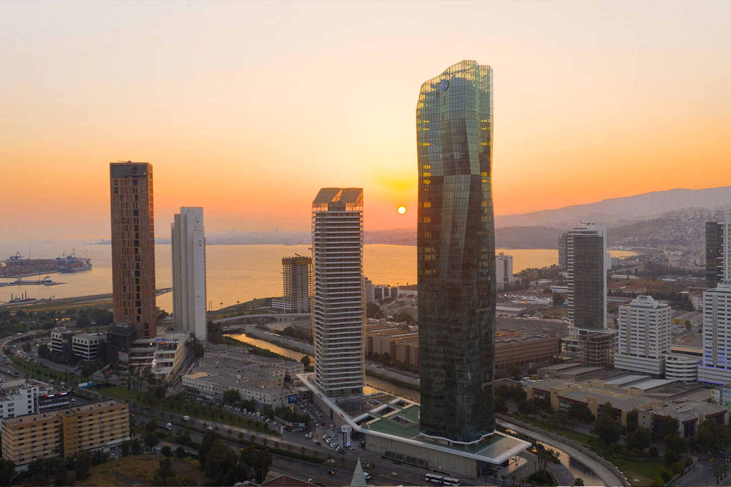 Twin towers overlooking Izmir Bay at sunset.