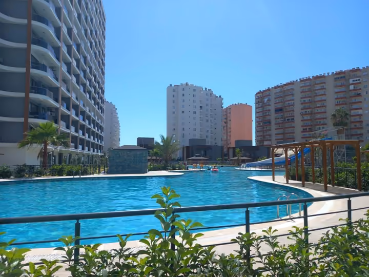 The shared outdoor pool photographed through the landscaped garden boundary.