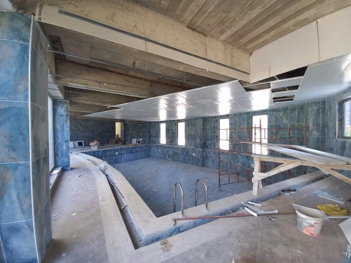The supplied photograph shows the indoor pool area still under construction; its present operating status is not established by this image.