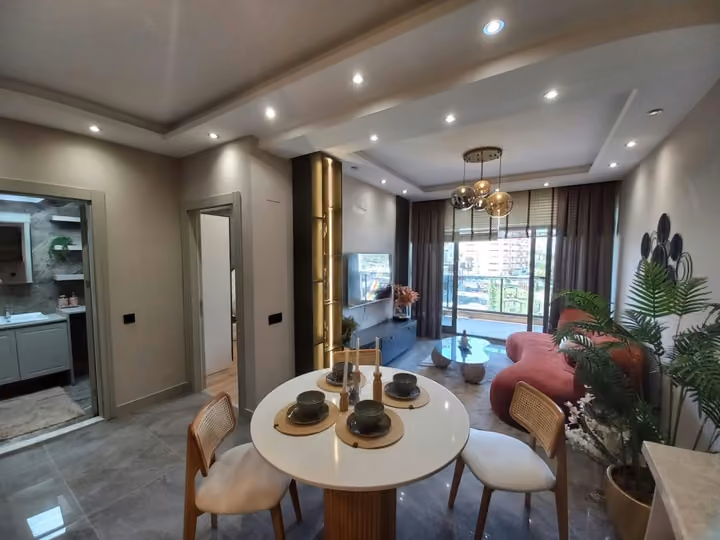 Furnished show apartment with an open kitchen, dining table and living area.