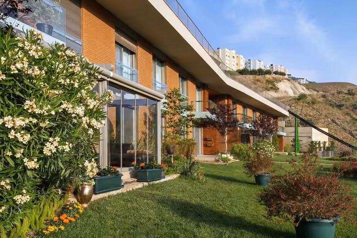 Daytime view of garden terraces beside the apartment facades.