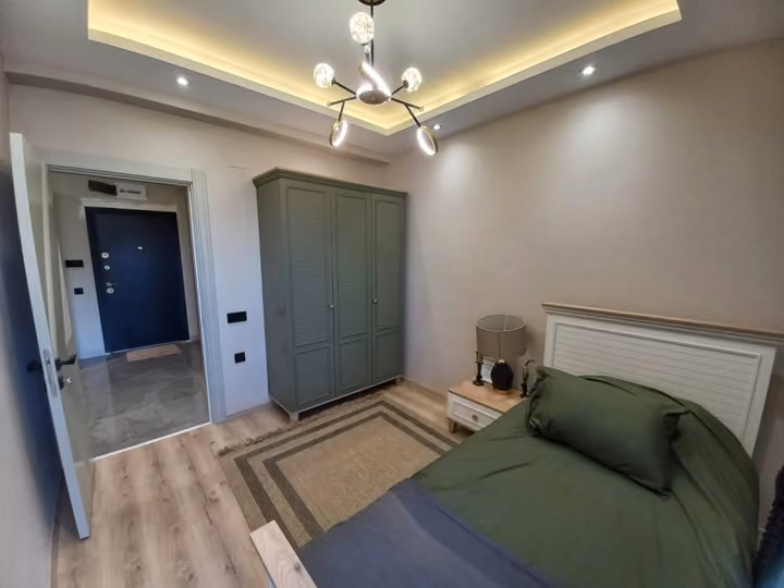 A furnished show apartment single bedroom with storage and an entrance doorway.