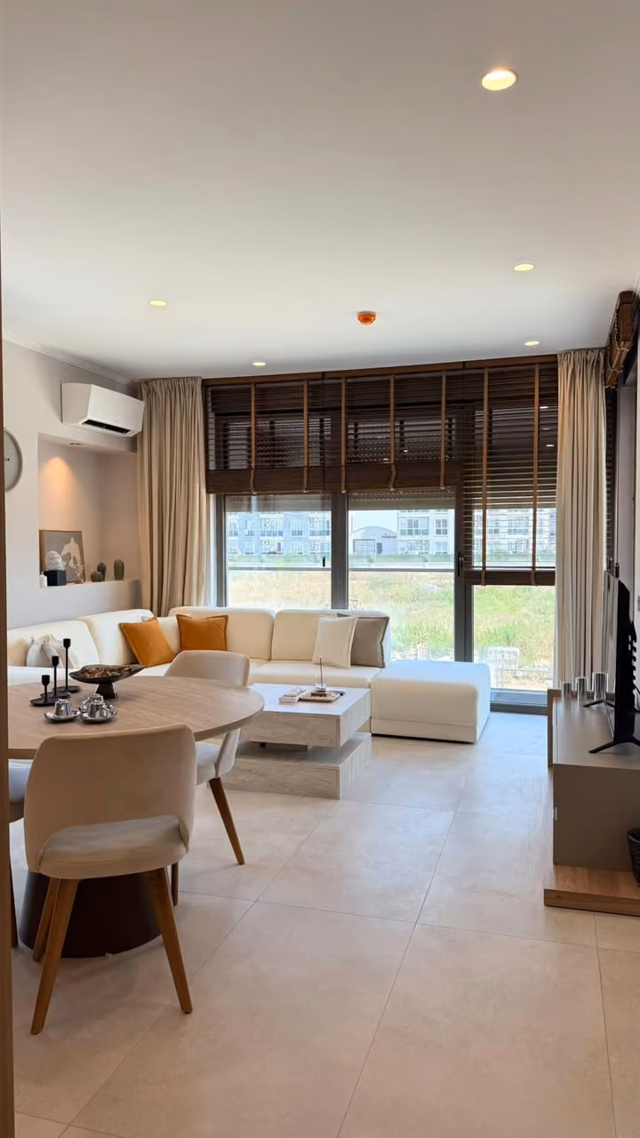 Sample apartment living area with an open kitchen and balcony access.