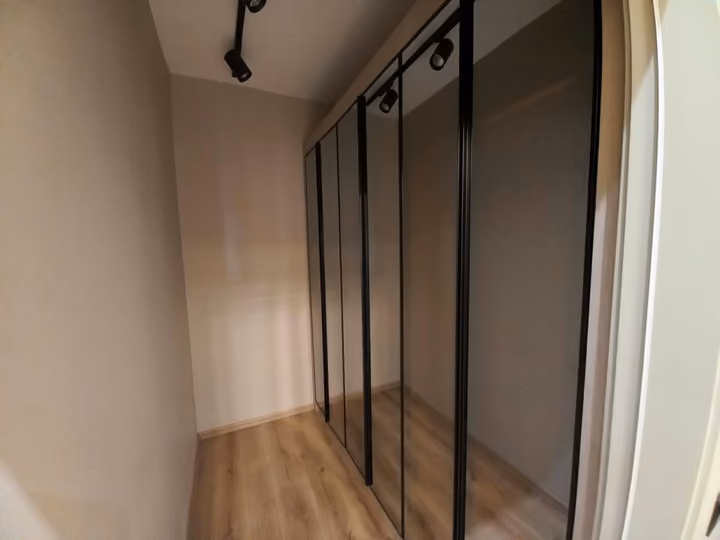 A show apartment dressing area with full-height storage cabinets.
