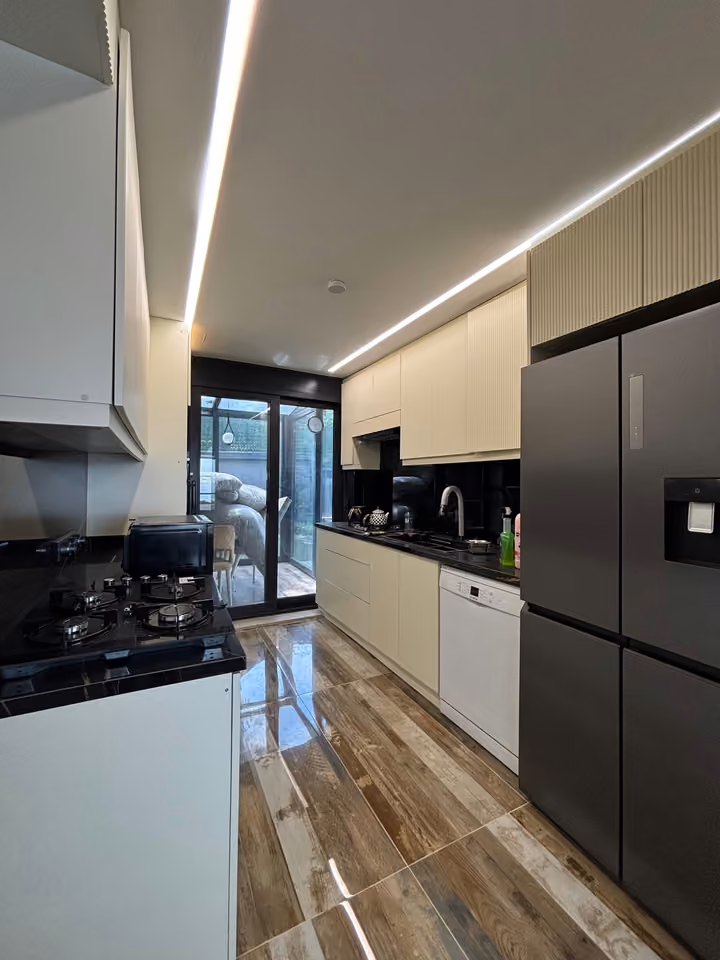 Kitchen showing the refrigerator, hob and dishwasher.