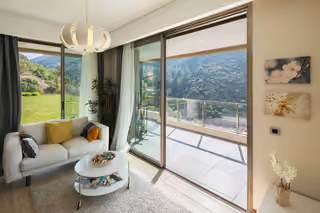 Living room opening onto a balcony with forest views.