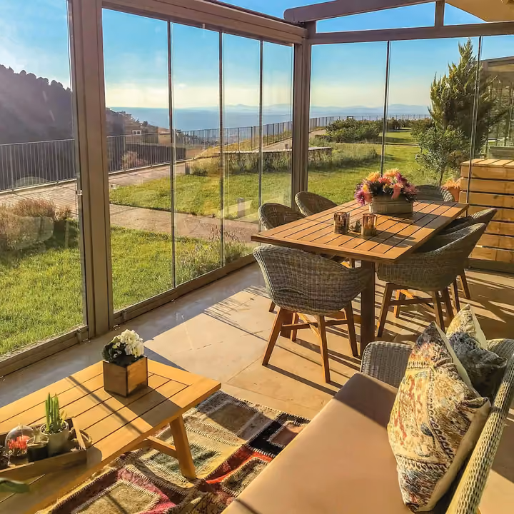 Glazed dining area overlooking a garden terrace.