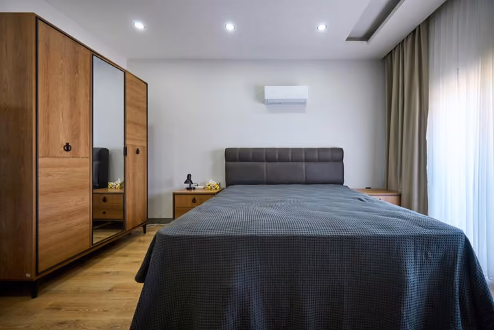 Double bedroom with a wardrobe, bedside storage and air conditioning.