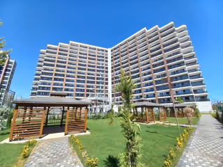 Two residential facades above the landscaped garden and shaded seating.