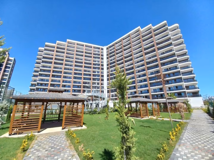 Two residential facades above the landscaped garden and shaded seating.