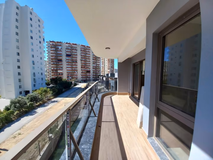 A long show apartment balcony with glazing along the apartment side.