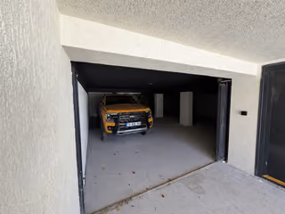 Covered garage and vehicle entrance beneath the villa.
