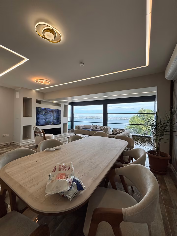 Furnished dining and living area with sea-facing windows.