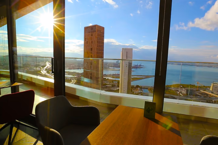 Apartment window overlooking the bay and nearby towers.