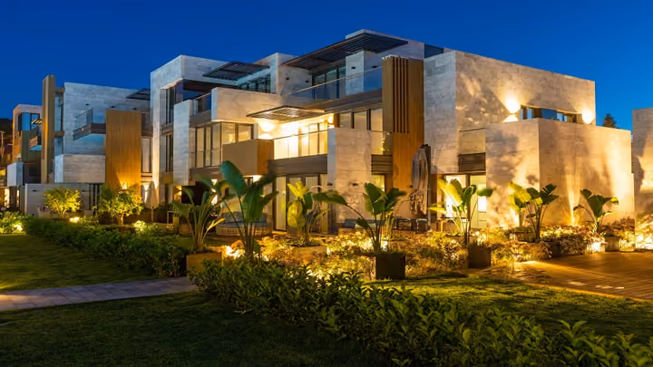 Garden and apartment facade illuminated at night in Boyalik, Cesme.