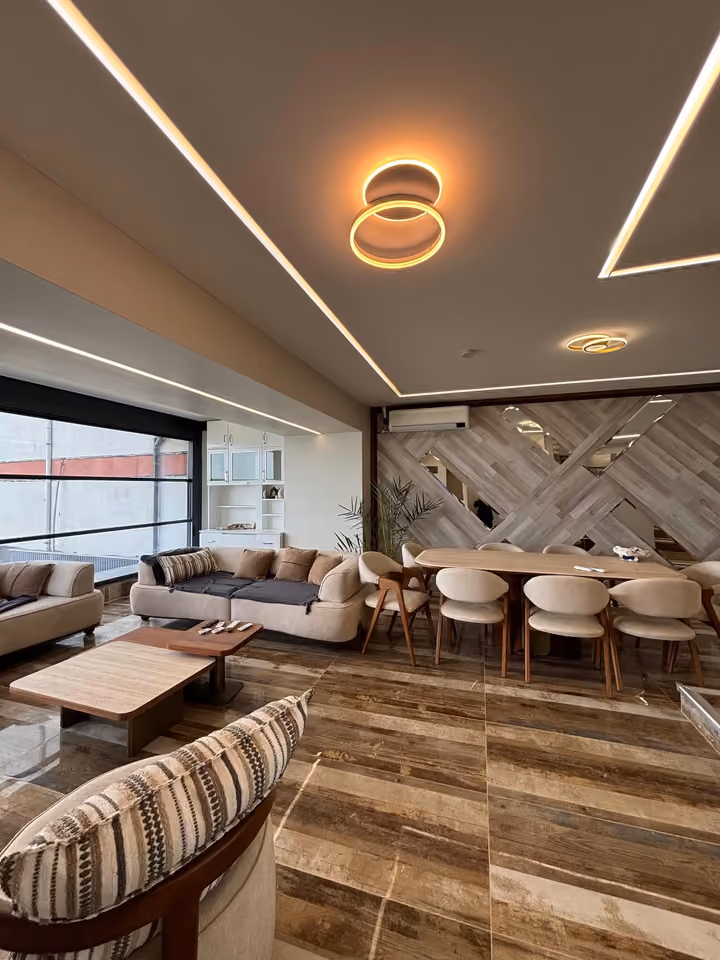 Furnished lounge and dining space with decorative wall panels.