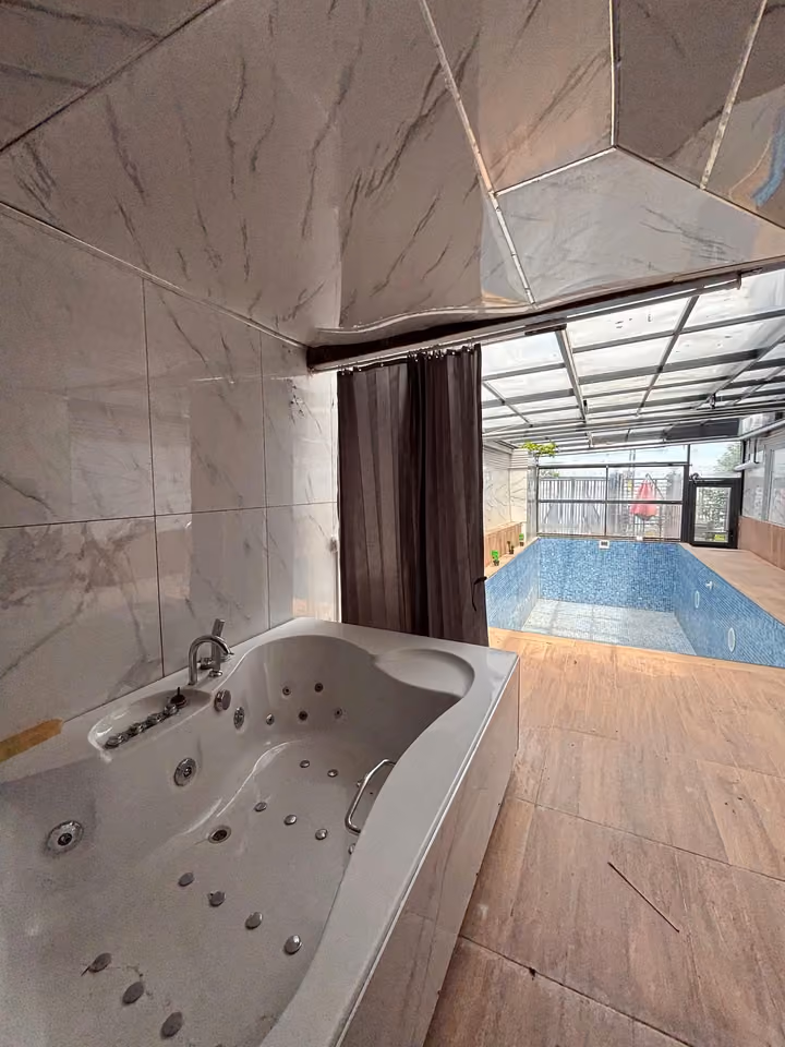 Jacuzzi beside the covered swimming pool, shown empty in the photograph.