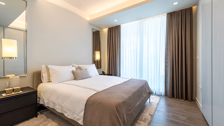 Bedroom with full-height windows and fitted furnishings.