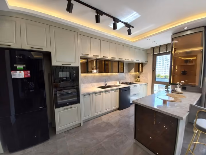 Fitted kitchen cabinetry and an island in a furnished show apartment.
