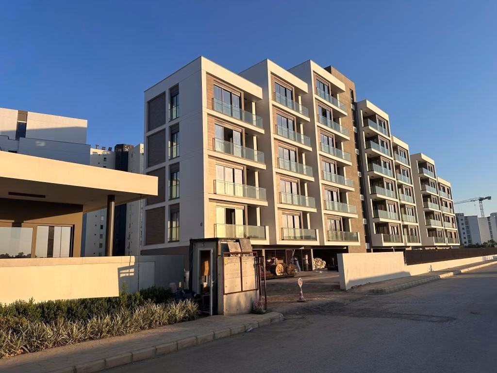 Exterior photograph of the apartment building and balconies in Kundu.