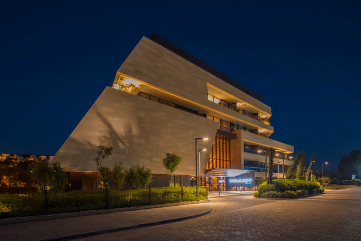 Illuminated seafront facade at night.