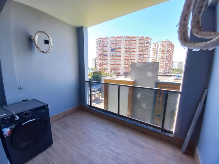 A smaller show apartment balcony with an external air-conditioning unit.